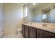Shows a bathroom featuring double sinks, tiled floors, a glass-enclosed shower, and neutral-colored walls at 20162 W Buchanan St, Buckeye, AZ 85326