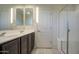 Bathroom featuring a double vanity with dark cabinets, tile floors, and a glass shower at 20162 W Buchanan St, Buckeye, AZ 85326