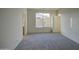 A bright, empty bedroom with neutral walls, carpet, and a window at 20162 W Buchanan St, Buckeye, AZ 85326