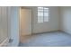 An empty bedroom featuring neutral walls, carpet, a window, and a white door at 20162 W Buchanan St, Buckeye, AZ 85326