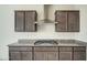 Close up of modern kitchen featuring stainless steel range hood, granite counters, and gas cooktop at 20162 W Buchanan St, Buckeye, AZ 85326