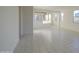 Open-concept living room with tile floors and natural light. View of kitchen at 20162 W Buchanan St, Buckeye, AZ 85326