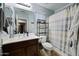 Standard bathroom with a single sink, vanity, toilet, shower, and some storage shelves at 21070 N Alexis Ave, Maricopa, AZ 85138