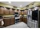 Well-equipped kitchen with dark wood cabinets, modern stainless steel appliances, and ample counter space at 21070 N Alexis Ave, Maricopa, AZ 85138