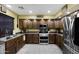 Well-equipped kitchen with dark wood cabinets, modern stainless steel appliances, and ample counter space at 21070 N Alexis Ave, Maricopa, AZ 85138