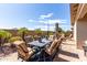 Charming backyard with dining set, lush landscaping, and blue outdoor rug at 22607 W Antelope Trl, Buckeye, AZ 85326