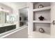 Bright bathroom boasts recessed shelves with decor items next to dark cabinets and white countertops at 22607 W Antelope Trl, Buckeye, AZ 85326