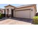 Attractive single-story home with neutral stucco, tile roof, brick accents, manicured lawn, and a two-car garage at 22607 W Antelope Trl, Buckeye, AZ 85326