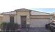 Charming single-story home with tile roof, decorative front door, two-car garage, and well-manicured landscaping at 22607 W Antelope Trl, Buckeye, AZ 85326