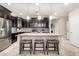 A stylish kitchen featuring dark cabinets, granite countertops, and stainless steel appliances at 22607 W Antelope Trl, Buckeye, AZ 85326