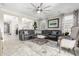 Spacious living room with neutral tile floors, large ceiling fan, modern furniture, and plenty of natural light at 22607 W Antelope Trl, Buckeye, AZ 85326