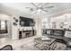 Open living room with a ceiling fan, neutral tile floors, modern furniture, and a fireplace at 22607 W Antelope Trl, Buckeye, AZ 85326