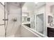 Bright bathroom featuring a glass partition, shower with a handheld wand, and wall-mounted soap dispensers at 22607 W Antelope Trl, Buckeye, AZ 85326