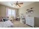This cozy bedroom features bright natural light from the window, a ceiling fan, and a playful decor at 26842 N 176Th Ln, Surprise, AZ 85387