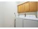 Functional laundry room with overhead cabinets, a washer, and a dryer at 26842 N 176Th Ln, Surprise, AZ 85387