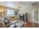 Living Room showcases wood flooring, a ceiling fan, a large window, and a comfortable couch at 26842 N 176Th Ln, Surprise, AZ 85387