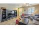 Comfortable living room boasts tile flooring, ceiling fan, and entertainment center at 26842 N 176Th Ln, Surprise, AZ 85387