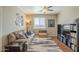 This living room features a cozy couch, media center, ceiling fan, and natural light perfect for relaxation at 26842 N 176Th Ln, Surprise, AZ 85387