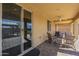 Relaxing covered patio with outdoor furniture, brick flooring, and a sliding glass door at 26842 N 176Th Ln, Surprise, AZ 85387