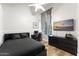 Stylish bedroom features a wood-look floor, dark furniture, and a window with curtains and streaming light at 2894 E Melody Ln, Gilbert, AZ 85234
