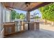 This covered patio features a stainless steel built-in grill with dining and bar area at 2894 E Melody Ln, Gilbert, AZ 85234
