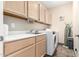 Well-equipped laundry room features ample cabinet space, a sink, and modern appliances at 37646 N Dream St, Carefree, AZ 85377