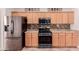 Kitchen with stainless steel appliances, wood cabinets, and tile backsplash at 38167 W Santa Clara Ave, Maricopa, AZ 85138