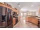 Open concept kitchen featuring wood cabinets and stainless steel appliances at 38167 W Santa Clara Ave, Maricopa, AZ 85138