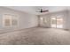 Spacious living room with neutral carpet and sliding glass door to backyard at 38167 W Santa Clara Ave, Maricopa, AZ 85138