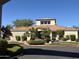 Exterior of the community clubhouse featuring a red tile roof, desert landscaping, and palm trees at 3830 E Lakewood E Pkwy # 2042, Phoenix, AZ 85048