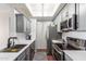 Galley kitchen features gray cabinets, stainless appliances, white countertops, tile backsplash and a stylish skylight at 3830 E Lakewood E Pkwy # 2042, Phoenix, AZ 85048