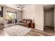Comfortable living room with ceiling fan and sliding glass doors to a balcony, plus a brown leather couch at 3830 E Lakewood E Pkwy # 2042, Phoenix, AZ 85048