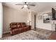 Living area featuring wood-look floors, ceiling fan, leather couch and view of kitchen passthrough at 3830 E Lakewood E Pkwy # 2042, Phoenix, AZ 85048
