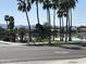 View of the waterfront featuring palm trees, landscaping, and houses reflecting on the water at 3830 E Lakewood E Pkwy # 2042, Phoenix, AZ 85048