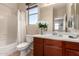 Cozy bathroom with a shower-tub combo, white vanity, and natural light from the window at 3914 E Constance Way, Phoenix, AZ 85042