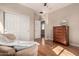 Neutral bedroom with a cozy chair, closet, wooden dresser and wood flooring at 3914 E Constance Way, Phoenix, AZ 85042