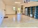 View of a spacious three car garage with epoxy flooring and built in shelving units at 3914 E Constance Way, Phoenix, AZ 85042