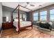 Spacious bedroom featuring a grand four-poster bed, natural light, and sleek hardwood floors at 3914 E Constance Way, Phoenix, AZ 85042