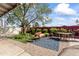 Outdoor seating area with a patterned rug and covered patio, all surrounded by lush greenery at 3931 W Augusta Ave, Phoenix, AZ 85051