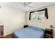 Simple bedroom featuring a queen-sized bed, ceiling fan, and a view of green outdoor foliage at 3931 W Augusta Ave, Phoenix, AZ 85051