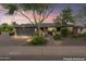 Charming single-story home with a manicured front yard, brick driveway, and cozy curb appeal at dusk at 3931 W Augusta Ave, Phoenix, AZ 85051