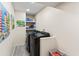 Well-lit laundry room with a modern washer and dryer, plus convenient shelving at 3931 W Augusta Ave, Phoenix, AZ 85051