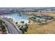 An aerial view of a neighborhood pond with community sports areas and desert landscaping at 41961 W Centennial Rd, Maricopa, AZ 85138