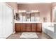 Bathroom featuring a double vanity, large mirror, and separate tub and shower at 41961 W Centennial Rd, Maricopa, AZ 85138