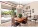Elegant dining area with stylish light fixture and access to outdoor patio and pool at 41961 W Centennial Rd, Maricopa, AZ 85138