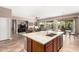 Open kitchen with island seating, modern stainless appliances, and seamless flow to living spaces at 41961 W Centennial Rd, Maricopa, AZ 85138