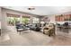 Spacious living room featuring plush sofas, a ceiling fan, and natural light from large windows at 41961 W Centennial Rd, Maricopa, AZ 85138