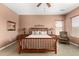 Main bedroom with a wooden bed frame, matching nightstands, and sitting area at 41961 W Centennial Rd, Maricopa, AZ 85138