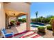 Covered patio with comfortable seating area and a beautiful view of the lush backyard and pool at 41961 W Centennial Rd, Maricopa, AZ 85138