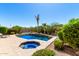 Backyard pool with integrated spa, beautiful landscaping, and desert charm under a bright sky at 41961 W Centennial Rd, Maricopa, AZ 85138